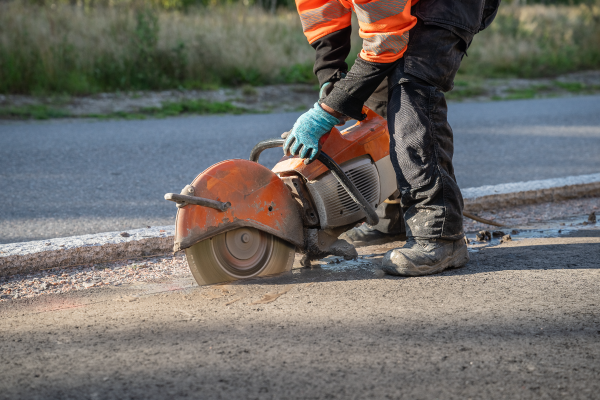 construction worker cutting a road for highway maintenance 