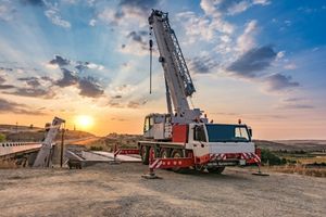 mobile crane on an active construction site at sunset