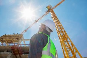 slinger signaller looking up at crane on construction site